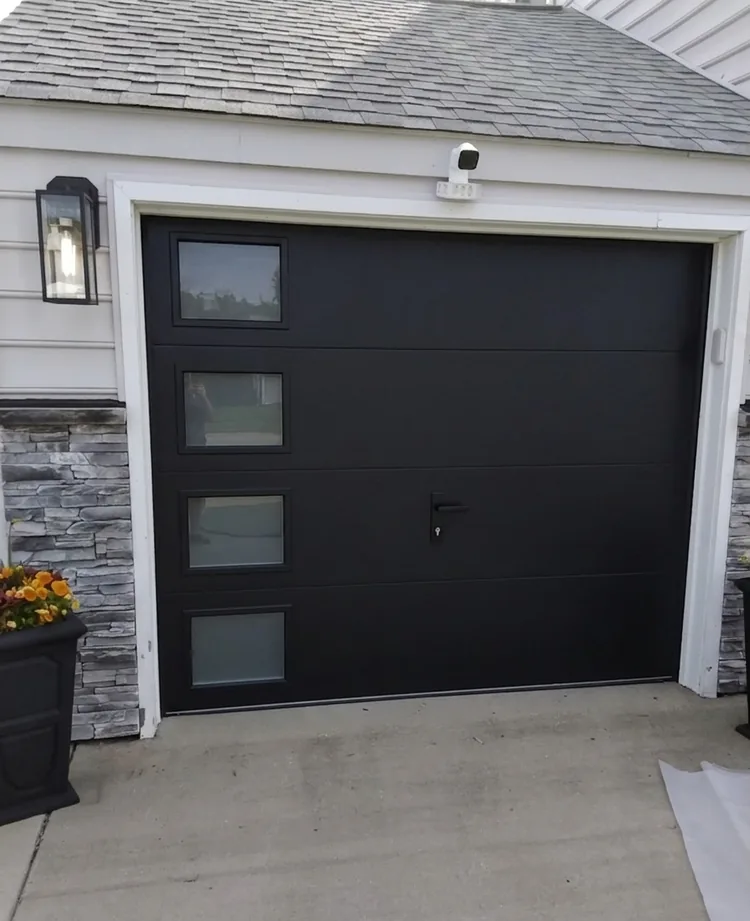 New black flush panel garage door after installation
